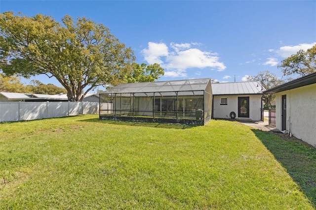 view of yard featuring glass enclosure and fence