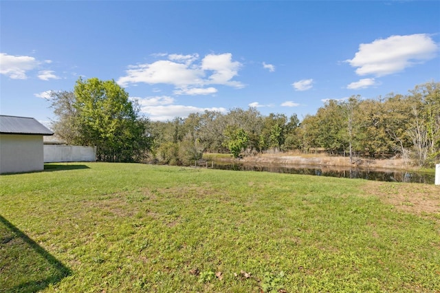 view of yard featuring a water view and fence