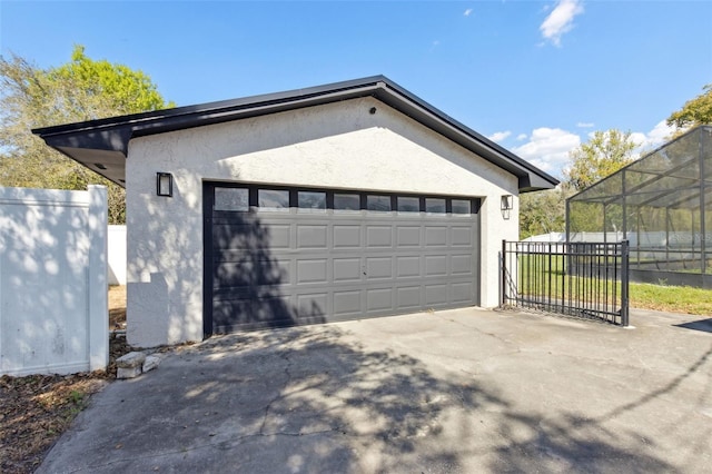 garage featuring fence and driveway