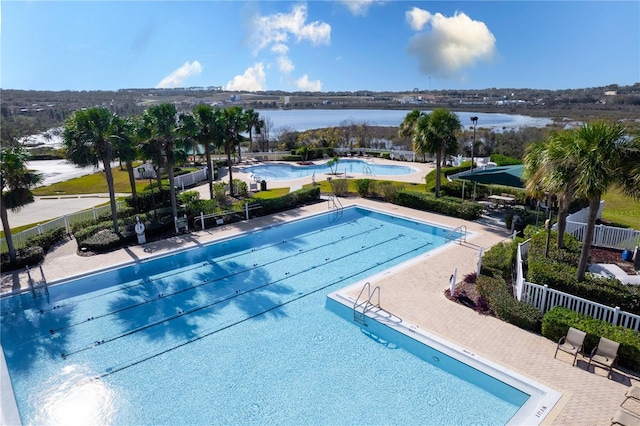 view of pool featuring a patio and a water view