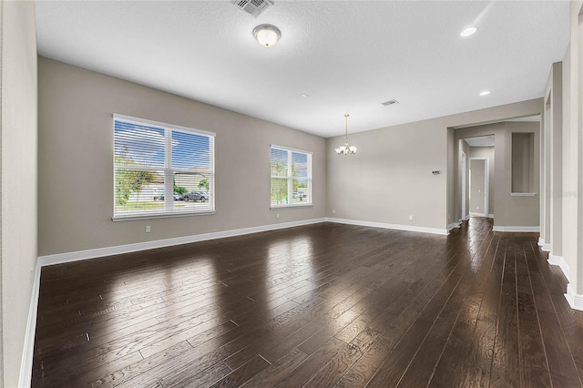 unfurnished room with dark hardwood / wood-style floors and a chandelier