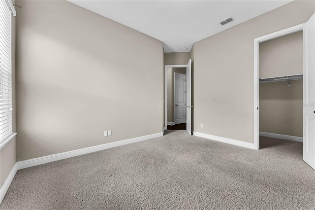 unfurnished bedroom featuring light colored carpet and a closet