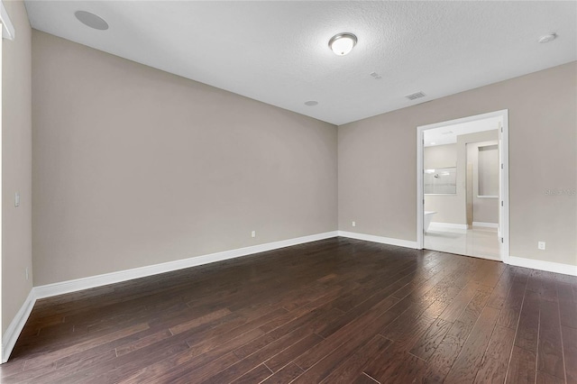 unfurnished room with hardwood / wood-style flooring and a textured ceiling