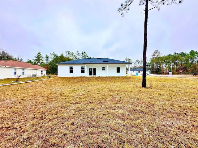 back of house with a lawn