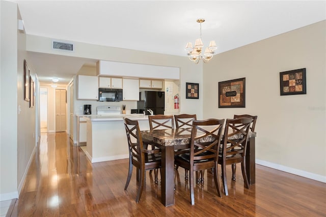 dining room with an inviting chandelier and wood-type flooring