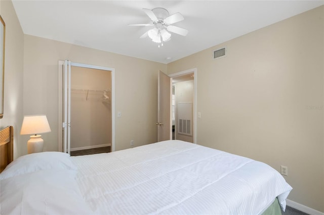 bedroom with ceiling fan, a spacious closet, carpet floors, and a closet