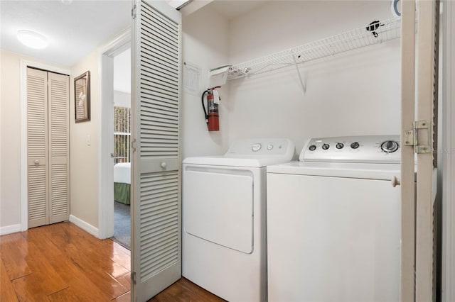 laundry area with wood-type flooring and washing machine and dryer