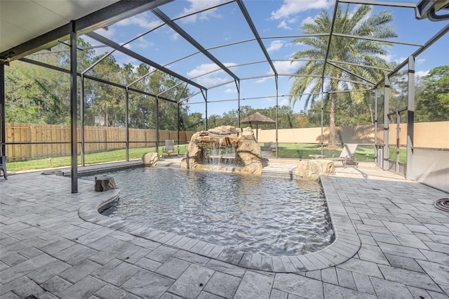 view of pool with a patio, pool water feature, and glass enclosure