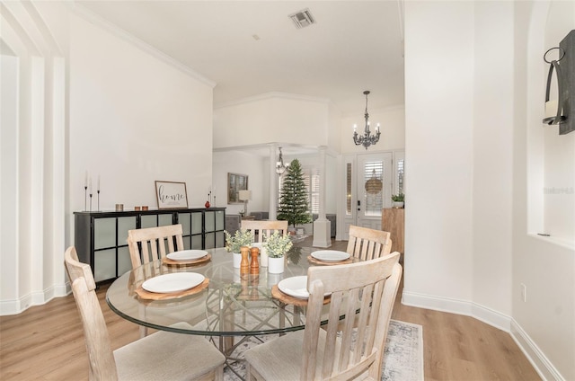 dining room featuring a notable chandelier, crown molding, and light hardwood / wood-style floors