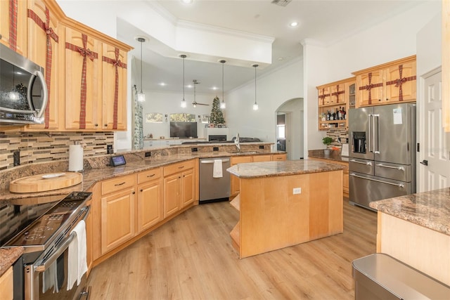 kitchen featuring pendant lighting, sink, crown molding, appliances with stainless steel finishes, and a kitchen island