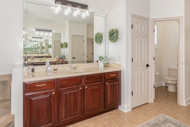 bathroom featuring vanity, tile patterned flooring, ornamental molding, and toilet