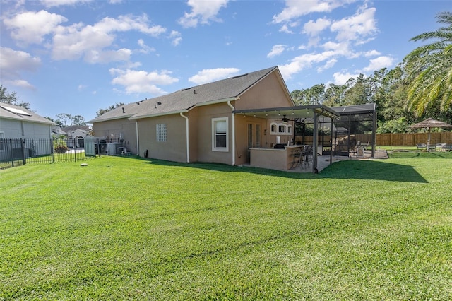 back of house featuring a yard, a patio, an outdoor bar, and glass enclosure