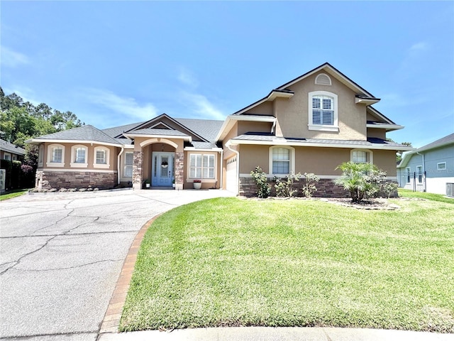 view of front of home featuring stucco siding, an attached garage, concrete driveway, and a front yard
