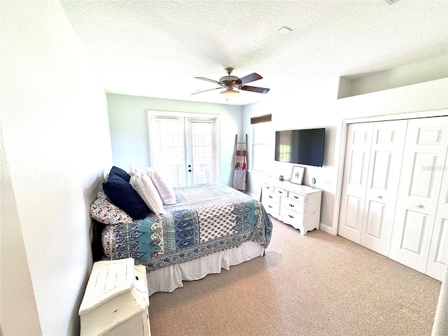 bedroom featuring light carpet, a textured ceiling, a closet, and ceiling fan