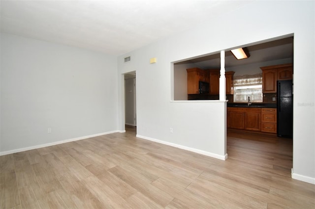 empty room featuring sink and light hardwood / wood-style flooring