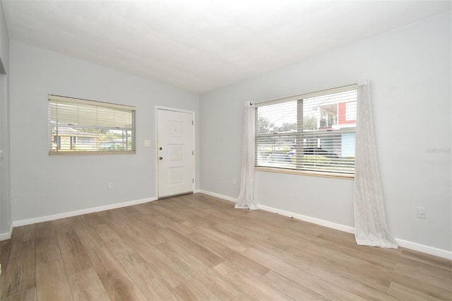 empty room featuring light hardwood / wood-style flooring and vaulted ceiling