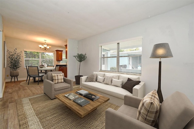 living room with plenty of natural light, a chandelier, and hardwood / wood-style floors