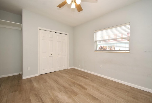 unfurnished bedroom featuring vaulted ceiling, ceiling fan, light hardwood / wood-style floors, and a closet