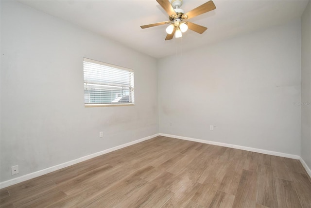 empty room with ceiling fan and light hardwood / wood-style flooring