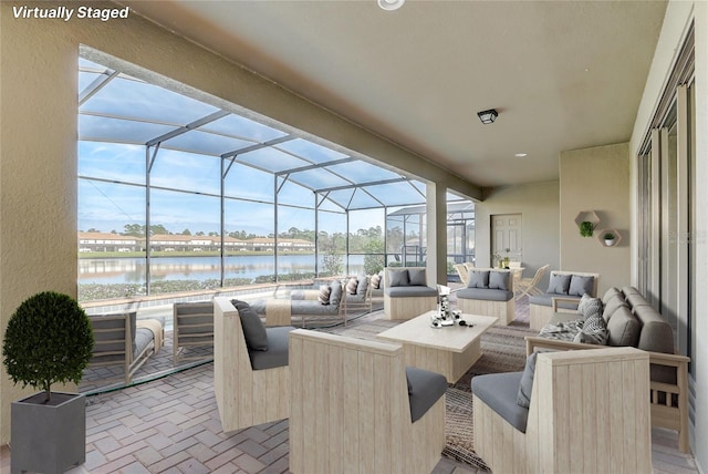 view of patio featuring an outdoor living space, glass enclosure, and a water view