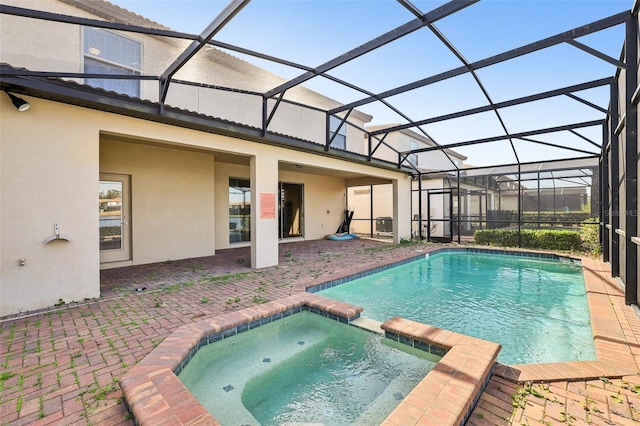 view of swimming pool featuring an in ground hot tub, a patio area, and glass enclosure