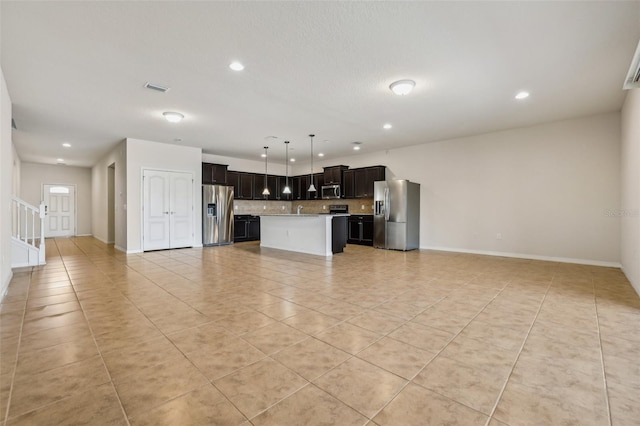 kitchen featuring tasteful backsplash, appliances with stainless steel finishes, a center island, and light tile patterned floors