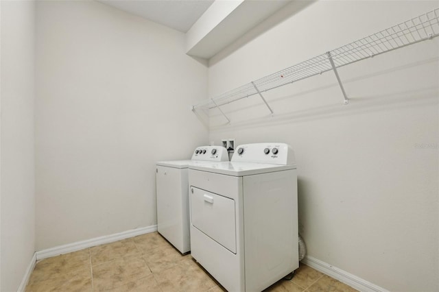 laundry area with washing machine and dryer and light tile patterned flooring