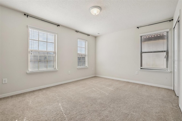 carpeted empty room featuring a textured ceiling