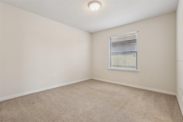 carpeted spare room with a textured ceiling