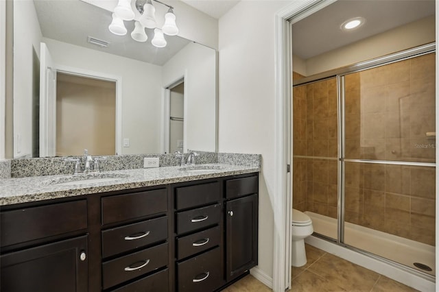 bathroom with tile patterned flooring, vanity, a notable chandelier, walk in shower, and toilet