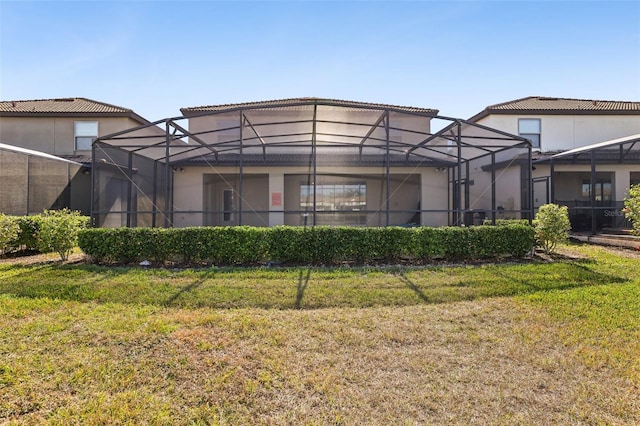 back of property with a yard and a lanai