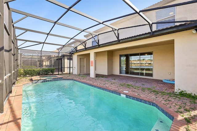 view of swimming pool with an in ground hot tub, a patio area, and glass enclosure