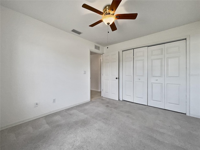 unfurnished bedroom with ceiling fan, light colored carpet, and a closet