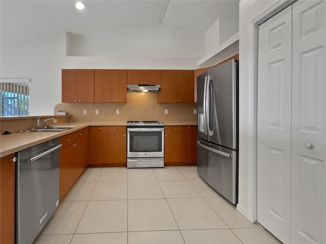 kitchen featuring stainless steel appliances, sink, light tile patterned floors, and decorative backsplash