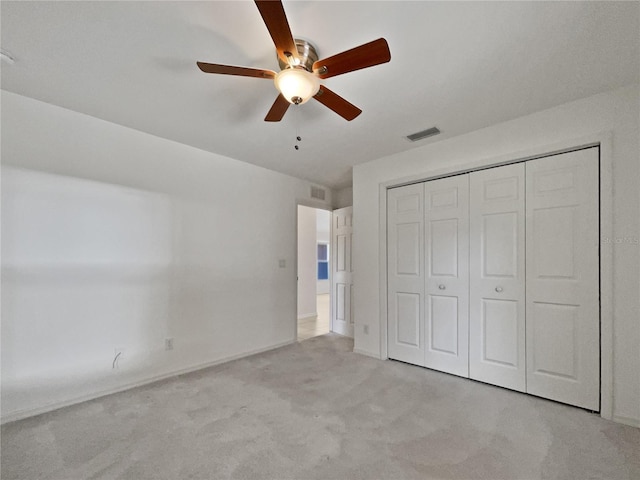 unfurnished bedroom featuring ceiling fan, light colored carpet, and a closet