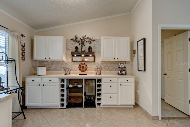 bar with white cabinetry, crown molding, vaulted ceiling, and backsplash