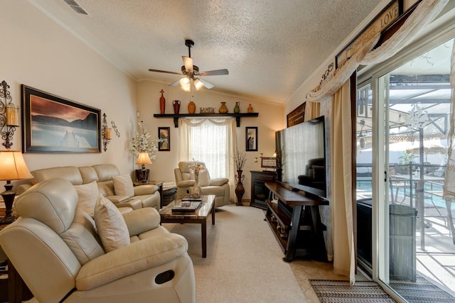 carpeted living room featuring vaulted ceiling, crown molding, ceiling fan, and a textured ceiling