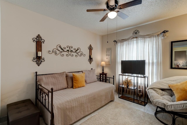 bedroom featuring ceiling fan, a textured ceiling, and light tile patterned floors