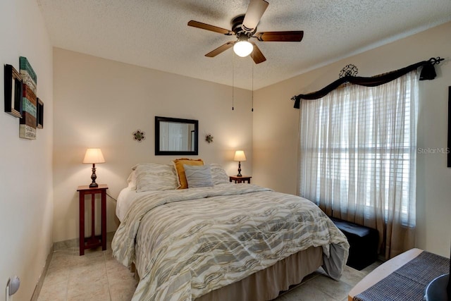 tiled bedroom featuring ceiling fan and a textured ceiling