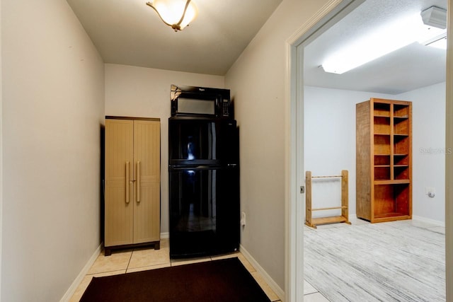 kitchen featuring light tile patterned flooring and fridge