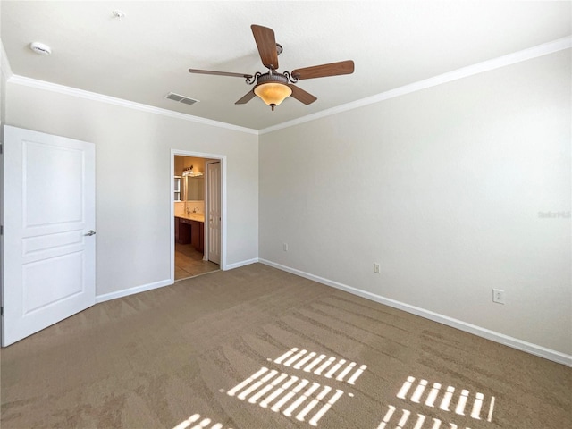 unfurnished bedroom featuring ceiling fan, light colored carpet, ornamental molding, and ensuite bath