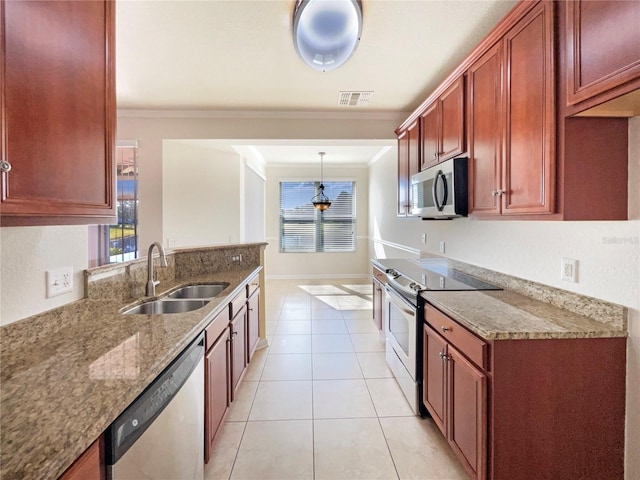 kitchen with light tile patterned flooring, appliances with stainless steel finishes, stone countertops, sink, and hanging light fixtures