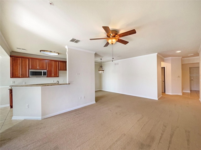 unfurnished living room with ceiling fan, ornamental molding, and light carpet