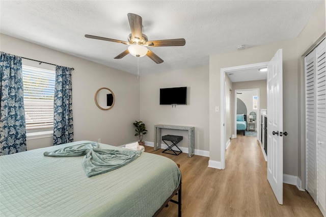 bedroom featuring a textured ceiling, light hardwood / wood-style floors, and ceiling fan