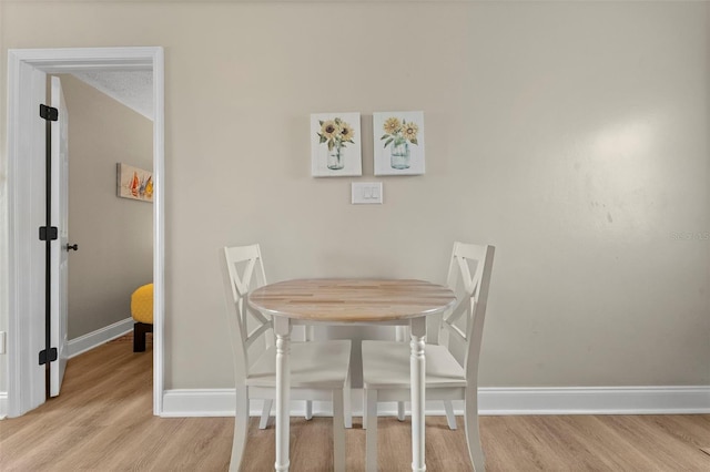 dining area featuring a textured ceiling and light wood-type flooring