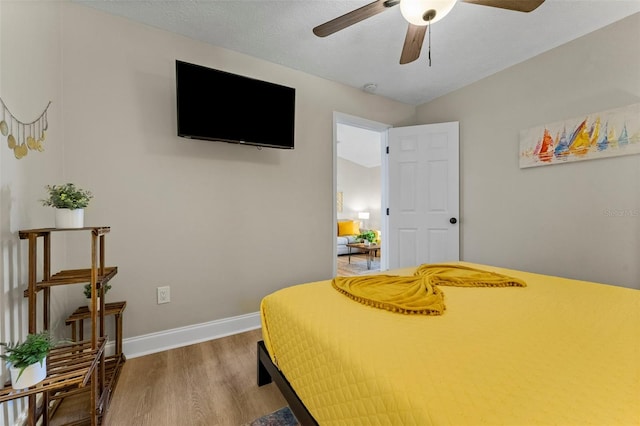 bedroom featuring hardwood / wood-style flooring, ceiling fan, and a textured ceiling