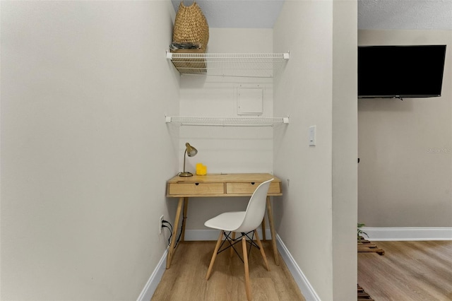 office with wood-type flooring and a textured ceiling