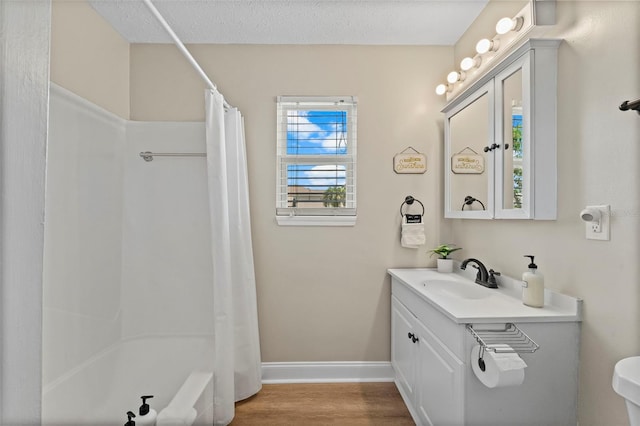 bathroom featuring shower / bath combination with curtain, vanity, a textured ceiling, and hardwood / wood-style flooring