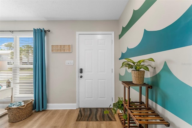 foyer entrance featuring hardwood / wood-style floors and a textured ceiling