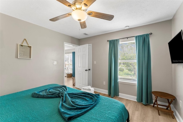 bedroom featuring ceiling fan, a textured ceiling, and light hardwood / wood-style floors